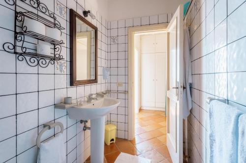 un baño con lavabo y espejo en Casa Li Galli with sea view, en SantʼAgata sui Due Golfi