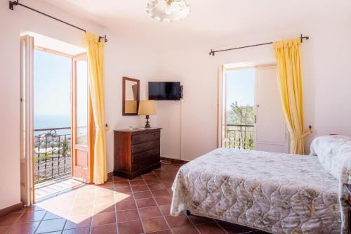 Un dormitorio con una cama y un balcón. en Casa Li Galli with sea view, en SantʼAgata sui Due Golfi