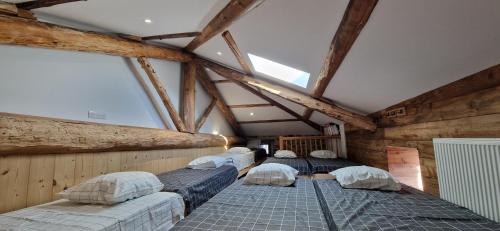 - 3 lits dans une chambre dotée de murs en bois dans l'établissement Domaine le Bouissou Du Mahun Gîtes de groupes en pleine forêt Ardéchoise, à Saint-Symphorien-de-Mahun