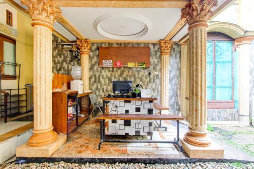 a room with columns and a table with a house on it at Hotel O Yogyakarta near MM UGM formerly Bama Guesthouse in Yogyakarta