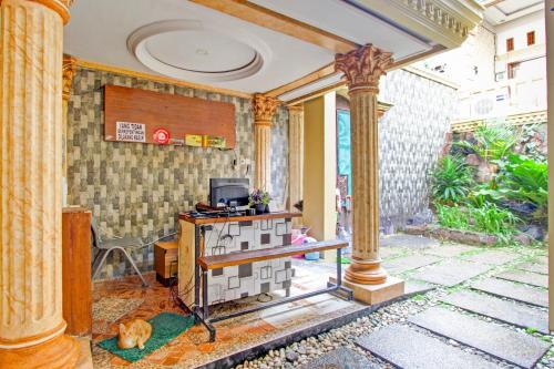 a room with columns and a tv on a table at Hotel O Yogyakarta near Jogja City Mall formerly Bama Guesthouse in Yogyakarta