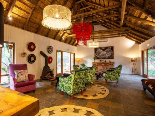 a large living room with chairs and a table at Etnika Manor House in Hoedspruit