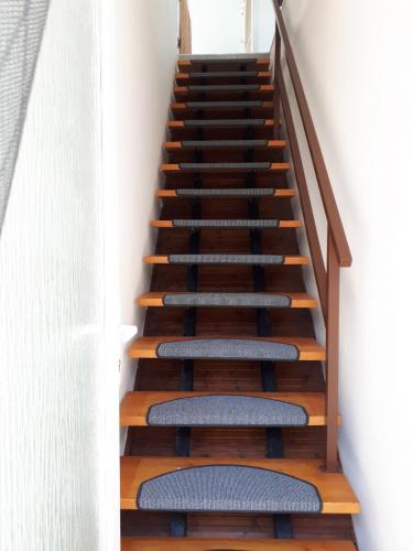 a staircase with wooden steps and blue cushioned seats at Napsugár apartman Balatonboglár in Balatonboglár