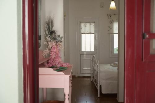 ein Zimmer mit einem rosa Tisch und ein Schlafzimmer in der Unterkunft Sunflower Kallimasia in Kallimasiá