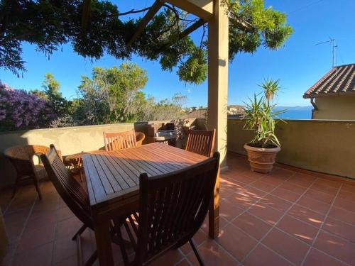 a wooden table and chairs on a patio at Costa degli Etruschi terrazza vista mare in Piombino