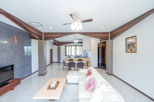 a living room with a white couch and a tv at Resort in青の洞窟 in Ishigaki Island