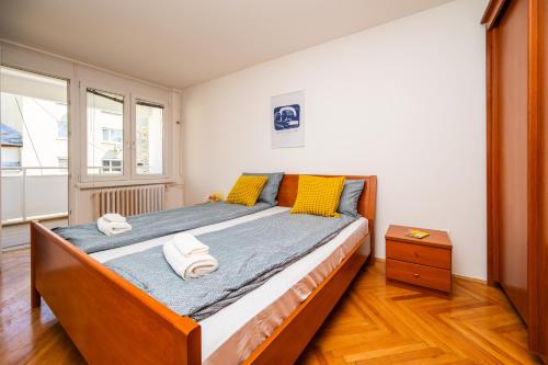a bedroom with a large bed with yellow pillows at Modern 1 BDR with Balcony in Sarajevo