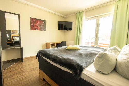 a bedroom with a bed and a large window at Havelpension in Rathenow