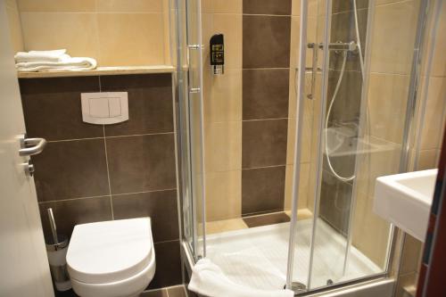 uma casa de banho com um chuveiro, um WC e um lavatório. em Altstadthotel Harburg em Hamburgo