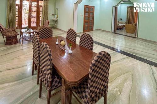 a wooden table and chairs in a living room at Arna Villa by VEO - Part of StayVista in Udaipur