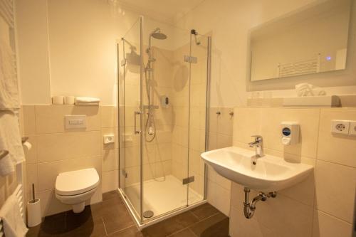 a bathroom with a shower and a toilet and a sink at Havelpension in Rathenow