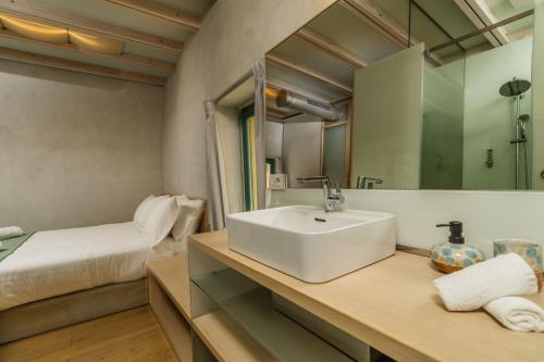 een badkamer met een wastafel en een bed bij Panaretos Deluxe Maisonette in Chania