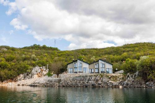 a house on an island in a body of water at Salt Lake Villas in Nikšić