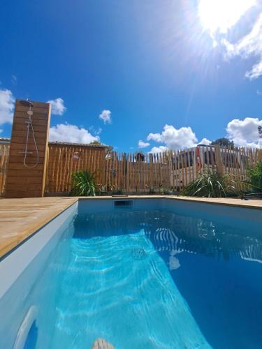 une piscine avec un ciel bleu en arrière-plan dans l'établissement Modern house with pool, between lake and forest, à Lacanau