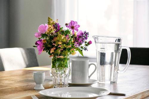 a vase of flowers sitting on a table with a pitcher at Gut Pälitzhof in Wustrow
