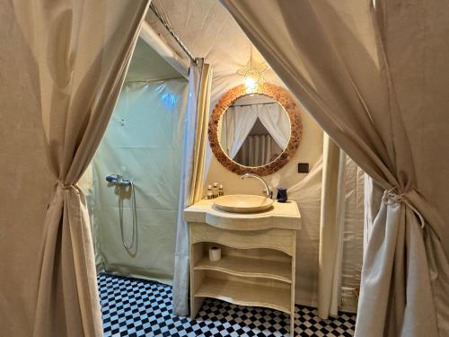 a bathroom with a sink and a shower with a mirror at Sahara Dream luxury Camp in Merzouga