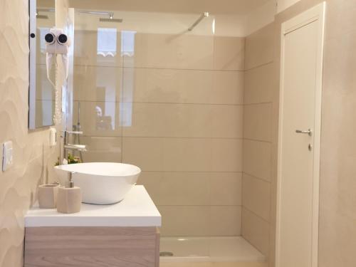 a bathroom with a white sink and a shower at Cartia Affittacamere in Ragusa
