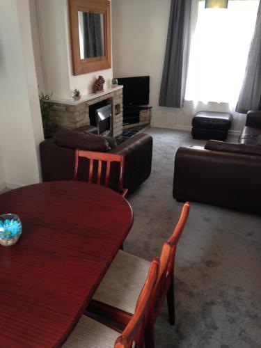 a living room with a table and a couch at Isambard Cottage in Weymouth