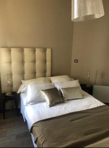 une chambre avec un grand lit avec des draps et des oreillers blancs dans l'établissement T2 pied dans l eau, à Ajaccio