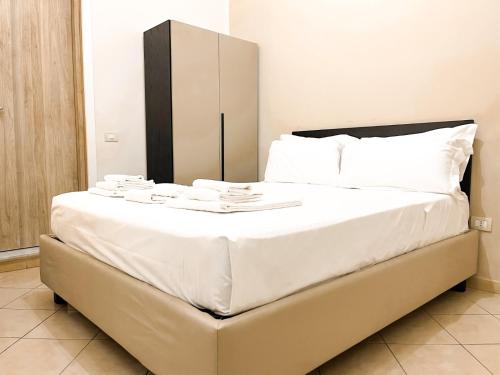 a large white bed with white sheets and white pillows at Brain Living Pagani in Pagani