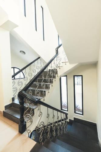 a staircase in a house with black railings at VILLA M - LAGOON 4 Calangute 3BHK Pool Facing, Breakfast Included in Old Goa