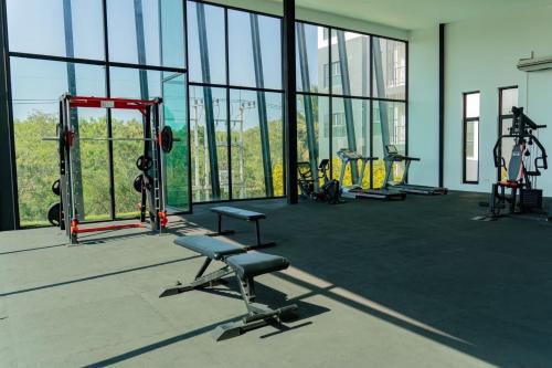 a gym with rows of equipment in a building with windows at The City Hatyai D20 in Sathani Khlong Rian