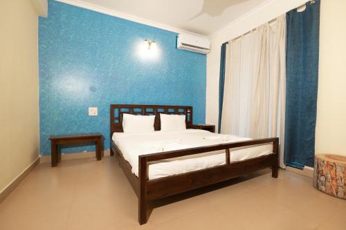 a bedroom with a bed and a blue wall at VILLA M - LAGOON 4 Calangute 3BHK Pool Facing, Breakfast Included in Old Goa