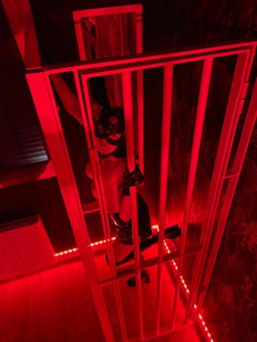 a person in a cell with red lights at Le baiser 2 Love room du plaisir interdit in Saint-Arnoult