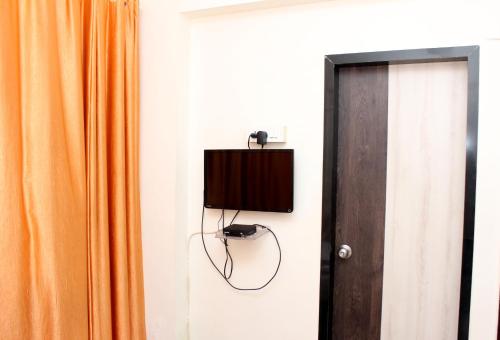 a television on a wall next to a door at New Pinnacle Services in Ghansoli