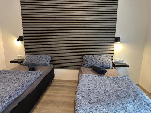 two beds in a room with a large window at Rhaunen Apartments in Rhaunen