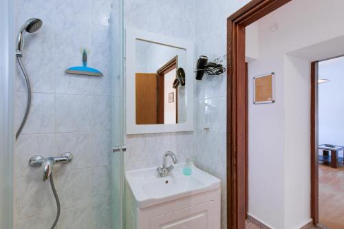 Un baño con ducha, lavabo y espejo. en Apartments Kurdija, en Punat