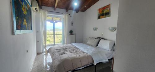 a bedroom with a bed in a room with a window at Horizon studio apartment in Palaiokatoúna