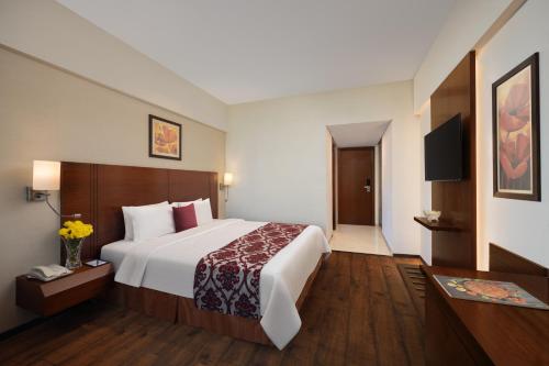 a hotel room with a large bed and a television at Fortune Select Exotica, Navi Mumbai - Member ITC Hotels' Group in Navi Mumbai
