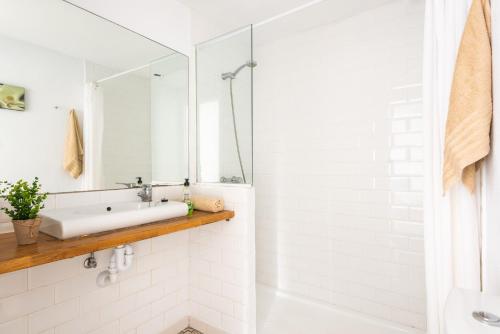 a white bathroom with a sink and a mirror at Apartamento Els Pins by Escapehome in Punta Grossa