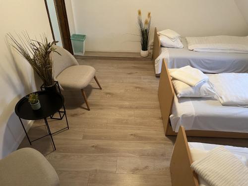 a room with three beds and a table and chairs at Delfin Szív Háza - Szauna és Jakuzzi in Tengőd