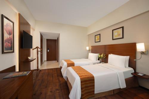 a hotel room with two beds and a television at Fortune Select Exotica, Navi Mumbai - Member ITC Hotels' Group in Navi Mumbai