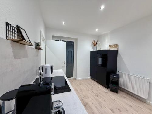 Una cocina con un refrigerador negro y una encimera. en Frisch saniertes Business Apartment "Profi Paul", en Neheim-Hüsten