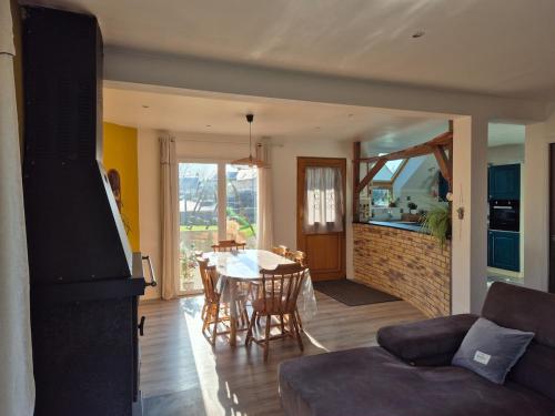 un salon avec une table et une salle à manger dans l'établissement Maison à 10km de la mer, à Hénansal