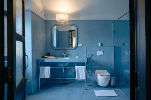 a blue bathroom with a sink and a toilet at Daulatgarh Resort in Udaipur