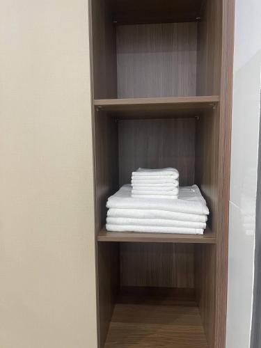 a stack of towels on a shelf in a bathroom at Hoàng Gia 2 Hotel in Ấp An Phú