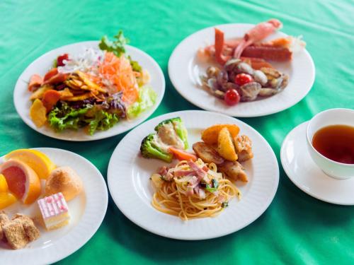 a group of plates of food on a green table at LiVEMAX Amms Canna Resort Villa in Ginoza