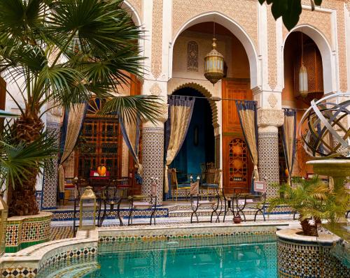un cortile con piscina in un edificio di Kassr Annoujoum - Luxury Boutique Riad in the Heart of Fès Medina a Fes