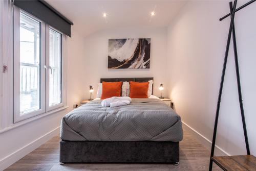 a bedroom with a large bed with orange pillows at 2-Bed Apartment, Basingstoke - Great Location in Basingstoke