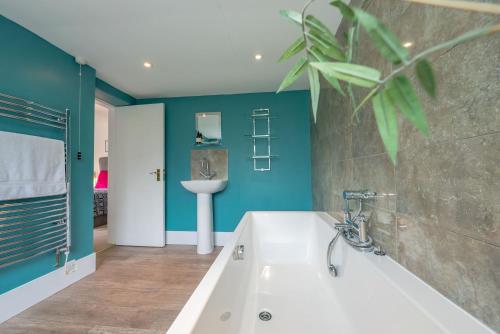 een badkamer met een ligbad en een wastafel bij Cae-Calch in Morfa Nefyn