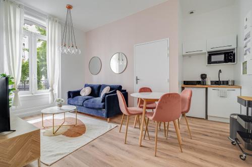 un salon avec un canapé bleu, une table et des chaises dans l'établissement Élégance et confort en plein cœur de Saint-Étienne, à Saint-Étienne