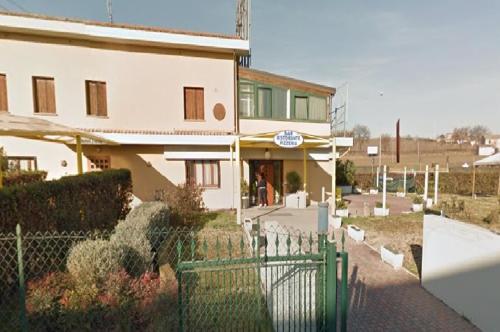 a white building with a fence in front of it at Hotel Fiera in Pesaro