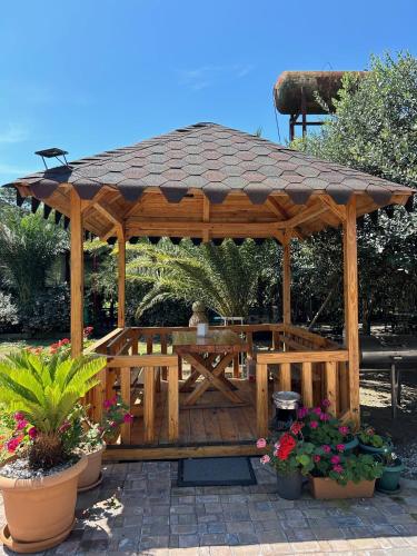 a wooden gazebo with a table and flowers at Hotel George in Ureki