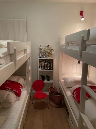 a room with two bunk beds and a red chair at Leisure apartment at Sinnes in Haugen