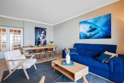 a living room with a blue couch and a table at Panorama Mer et Plage Cap d Ail proche Monaco in Cap d'Ail