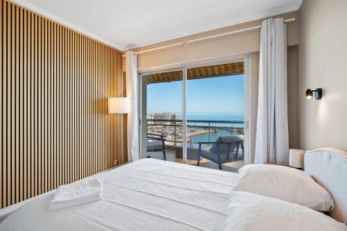 a bedroom with a bed and a view of the ocean at Panorama Mer et Plage Cap d Ail proche Monaco in Cap d'Ail